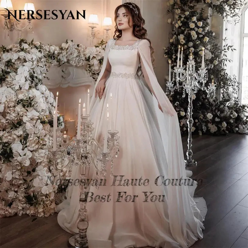 Nersesyan Vintage Long Cape Sleeves Formal Wedding Gowns Sequare CollaSPECIFICATIONSBrand Name: NersesyanStyle: ClassicNeckline: Square CollarSleeve Length(cm): FullTrain: Court TrainOrigin: Mainland ChinaCN: JiangsuDresses Length: FloJohnny TirakJohnny TirakNersesyan Vintage Long Cape Sleeves Formal Wedding Gowns Sequare Collar Glitter Beads Bridal Dresses